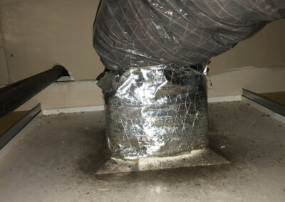 Improperly sealed duct connection with visible dirt and worn insulation tape, affecting the efficiency of the HVAC system.