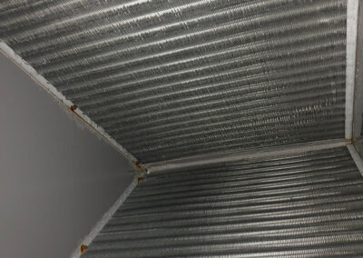 Clean metal fins inside an HVAC system after professional cleaning by American Clean Air, with rust removed and surfaces free of grime.