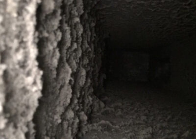 Close-up view of a heavily clogged vent, filled with thick dust, lint, and debris.