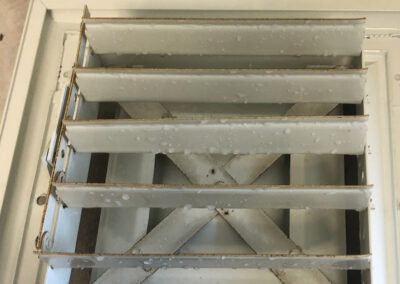 Clean air vent after mold and dust removal, with no visible contaminants, and slight water droplets remaining from the cleaning process by American Clean Air.